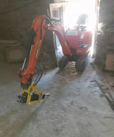 Mini excavadora picando suelo de cemento