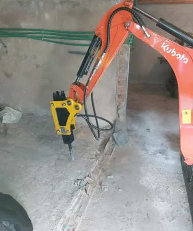 Mini excavadora picando suelo de cemento