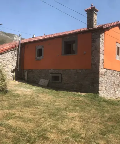 Casa de piedra rodeada de césped