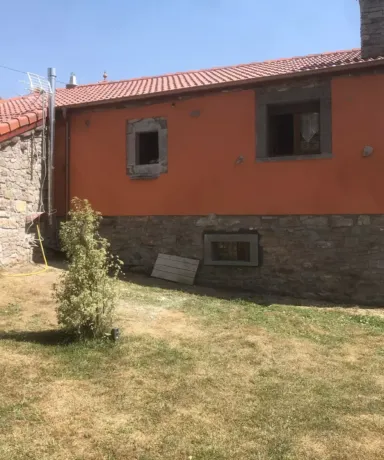 Casa de piedra rodeada de césped