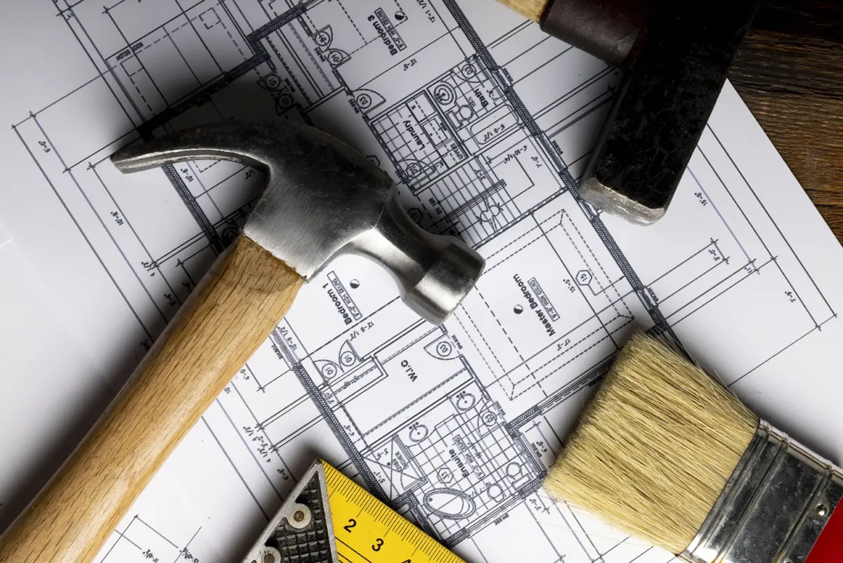 Un plano, dos martillos, una brocha y una escuadra